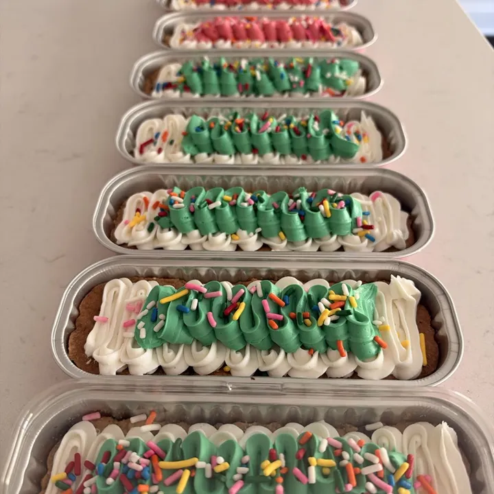 A row of ribbon-design cookie cakes in green and coral